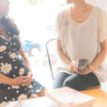 pregnant woman engaging with her birth doula in the sunshine of Belfast, Northern Ireland