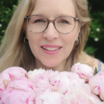 Doula of Belfast behind a bunch of pink peonies