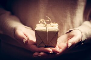 Giving a gift, handmade present wrapped in paper